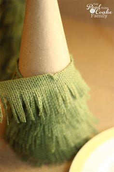 a close up of a small green object on a table with a plate in front of it