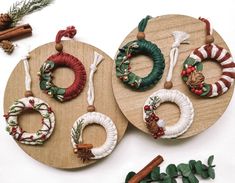 two christmas wreaths are hanging on wooden boards