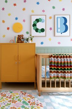 a baby's room with colorful wallpaper and decor