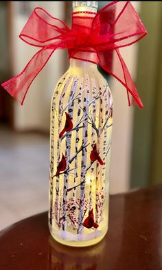 a glass bottle decorated with birds and branches