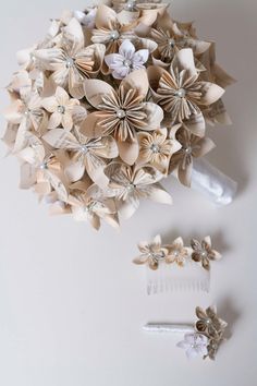 a bunch of paper flowers sitting on top of a white table next to scissors and combs