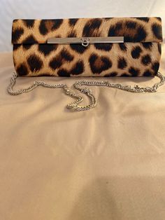 Beautiful clutch bag with a detachable chrome chain, a small inside pocket for credit cards, plenty of room for a mobile phone, keys, small makeup kit, lipstick and money. This bag is designed by British fashion designer Shakeel Rabbaney using a typical Animal print pattern with sleek chrome clasp. All our bags are limited edition with a maximum of ten made in each pattern. Rectangular Evening Bags With Card Slots, Evening Pouch Shoulder Bag With Card Slots, Chic Bags With Card Slots, Chic Rectangular Case Bag With Card Slots, Elegant Handheld Bag With Card Slots, Chic Brown Rectangular Case Clutch, Chic Clutch With Card Slots, Elegant Bags With Card Slots, Elegant Handheld Wallets With Card Slots