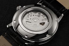 Movement: F6722 Caliber Automatic, Hand-winding, Hacking Movement Power Reserve: Approximately 40 hours Features: Date, Exhibition Caseback Crystal: Mineral Dial Color: Black Case Material: Stainless Steel Case Diameter: 41.6 mm without crown Lug-to-Lug Length: 49 mm Case Thickness: 12.1 mm Water Resistance: 50 m Crown: Push / Pull Bezel Material: Stainless Steel Bezel Function: Stationary Band Material: Leather (Black) Clasp: Tang Buckle Lug Width: 22 mm Warranty Type: 1 Year Orient Watch USA W Orient Watch, Shop Icon, Black Case, Type 1, Stainless Steel Case, Fashion Watches, Latest Fashion, Leather, Design