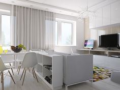 a living room with white furniture and a flat screen tv mounted on the wall next to a dining table