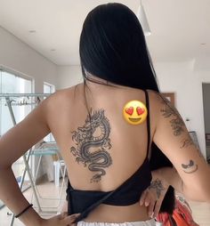 the back of a woman's body with tattoos and emoticions on it