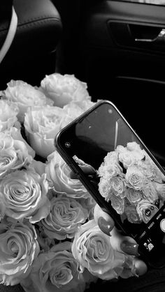 a cell phone sitting on top of a bouquet of flowers next to a car steering wheel