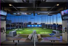 an indoor golf course is shown in the distance with many tables and couches around it