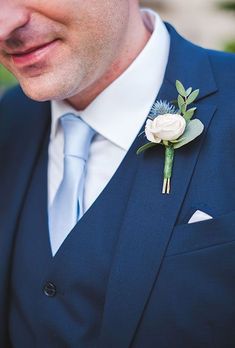 a man in a suit and tie with a boutonniere on his lapel