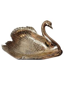 a brass swan figurine on a white background