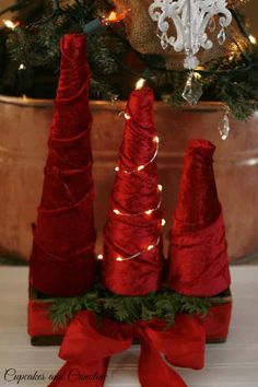 three red cones are sitting in front of a christmas tree