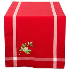 a red table runner with white trim and flowers on the front, along with a green leafy applique