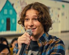 a young man holding a microphone in front of him