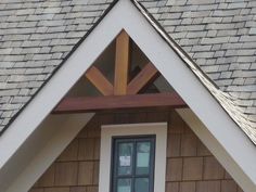 a cat sitting on top of a window sill in front of a wooden roof