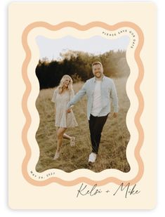 a couple is holding hands and walking through the grass in front of an ornate frame