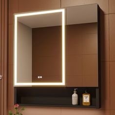 a bathroom sink with a lighted mirror and soap dispenser next to it