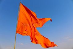 an orange flag waving in the wind on a sunny day stock photos, images and clippings