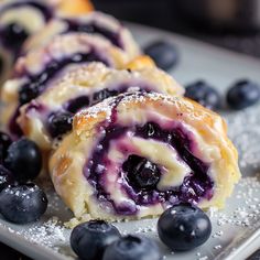 blueberry rolls on a plate with powdered sugar