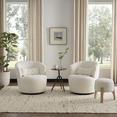 a living room with two white chairs and a small table in front of the window