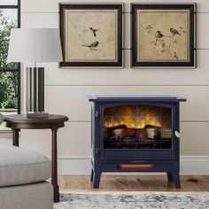 a living room with a fireplace and two paintings on the wall