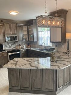 a large kitchen with granite counter tops and stainless steel appliances, along with an island in the middle