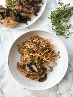 two white plates topped with pasta and mushrooms