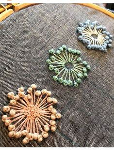 three different colored beaded designs on a piece of cloth