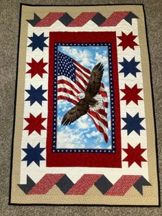 an eagle flying over the american flag quilt