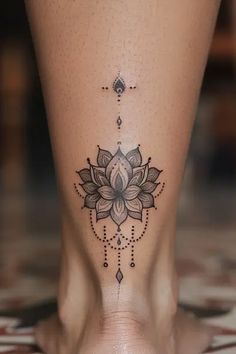 a woman's foot with a flower tattoo on the side of her leg,