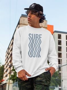 Get ready to hit the waves with our surf sweater! This is a piece of clothing that features a bold, graphic design of the word "surf" in a distinctive font with a wavy vibe. This type of sweater is popular among those who love to hit the waves and embrace a laid-back, beachy lifestyle. It's the perfect garment for wearing on a casual day out at the beach, or for hanging out with friends on a cool summer evening. The sweater is made from a soft and comfortable fabric that will keep you warm and c Surf T Shirts, Minimalist Sweater, Wave Sweater, Surf Apparel, Gifts For Surfers, Surf Design, Surf Lifestyle, Surf Tshirt, Surf Outfit