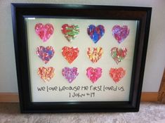 a framed photo with hearts and the words we love because the first loved us