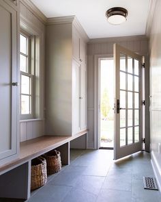 an empty entryway with two large doors and baskets on the floor next to it