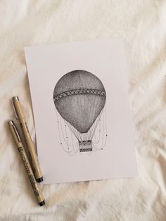 a drawing of a hot air balloon on top of a bed next to two markers