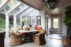 a dining room table and chairs in front of a large glass wall with lots of windows