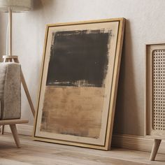 an empty frame on the floor next to a chair and lamp in a living room