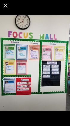 a bulletin board with focus wall written on it and a clock mounted to the wall