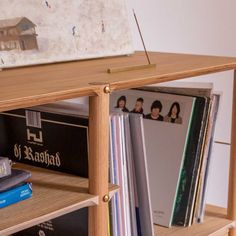 the books are stacked on top of each other in front of a wooden shelf with cd's