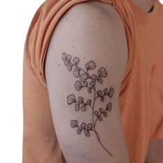 a woman with a tattoo on her arm is looking at the camera and has a flower in it