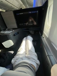 someone is laying down in the seat on an airplane