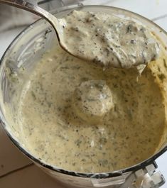 a spoon in a food processor filled with gravy and some sort of sauce