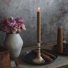 a candle and some flowers in a vase on a table