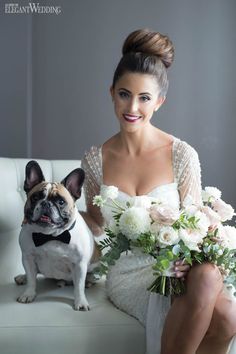 a woman sitting on a couch next to a dog with flowers in it's lap