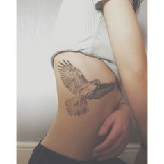 a woman with a bird tattoo on her stomach