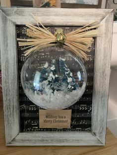 a christmas ornament hanging from a wooden frame