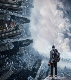 a man standing on top of a tall building looking down at the city below him