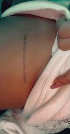 the back of a woman's stomach with an inscription on her left arm that reads,