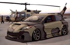 the car is camouflaged in front of a helicopter