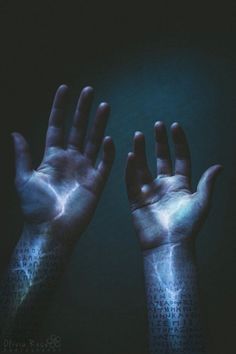 two hands that are covered in purple and blue light, with their fingers spread out to the side