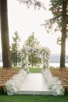 an outdoor ceremony setup with white flowers and greenery