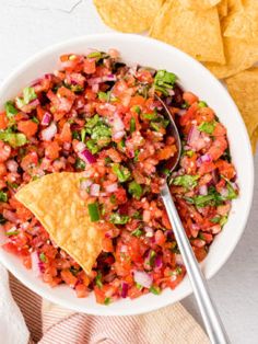 a white bowl filled with salsa and tortilla chips on top of a table