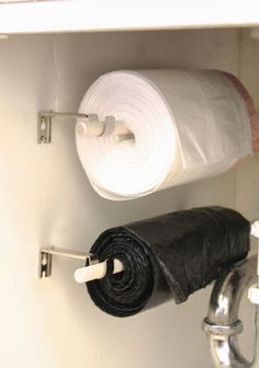 a roll of toilet paper sitting on top of a shelf next to a roll of trash bags